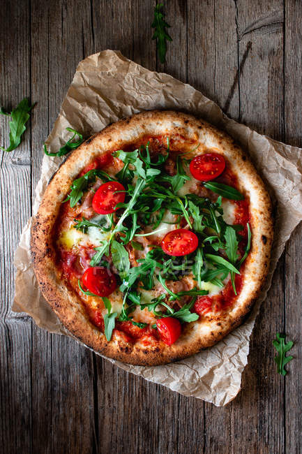 Deliziosa pizza con pomodori, rucola e mozzarella su fondo rustico in legno — Foto stock