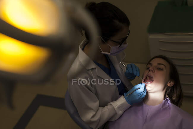 Mujer dentista atendiendo a un paciente - foto de stock