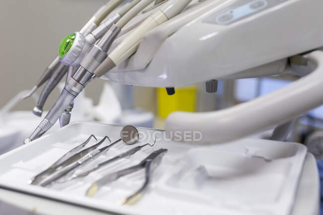 Dentist steel tools like sharp, scraper, carver, drill and mirror in tray on table in dental cabinet in clinic — Stock Photo