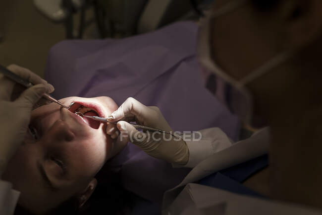 Femme dentiste s'occupant d'un patient — Photo de stock