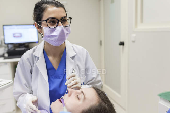 Woman dentist attending to a patient — Stock Photo