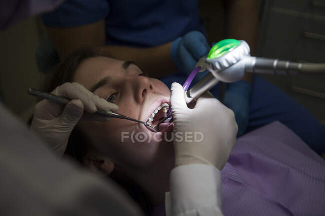 Mujer dentista atendiendo a un paciente - foto de stock