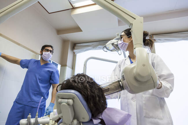 Стоматолог і його асистент приймають рентгенівський знімок зубного ряду пацієнта — стокове фото