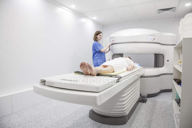 Middle-aged woman and her doctor in an open MRI machine waiting for the test to start — Stock Photo