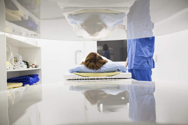 Frau mittleren Alters und ihr Arzt in einem offenen MRT-Gerät, das auf den Teststart wartet — Stockfoto