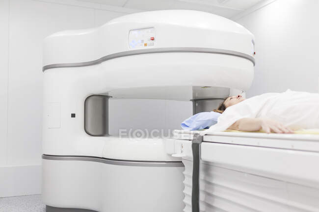 Mulher de meia-idade em uma máquina de ressonância magnética aberta à espera que o teste comece — Fotografia de Stock