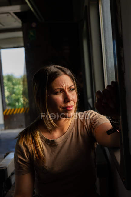 Soldatin schaut aus dem Fenster, während sie mit Militärfahrzeug durch die Landschaft fährt — Stockfoto