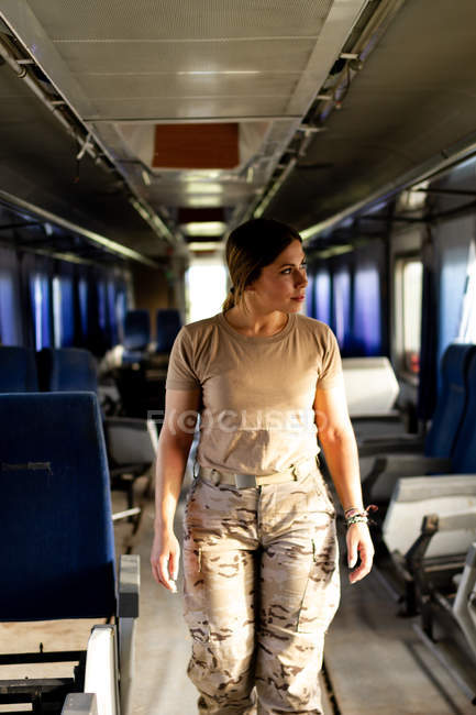 Серйозна військова жінка в уніформі, дивлячись далеко, стоячи всередині армійського транспорту — стокове фото