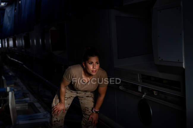 Fuerte soldado femenino de pie dentro del transporte militar moderno - foto de stock
