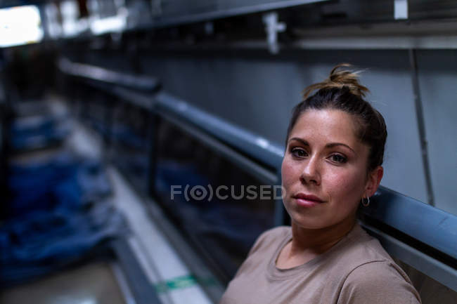 Приваблива жінка-солдат дивиться на камеру всередині сучасного військового транспорту — стокове фото