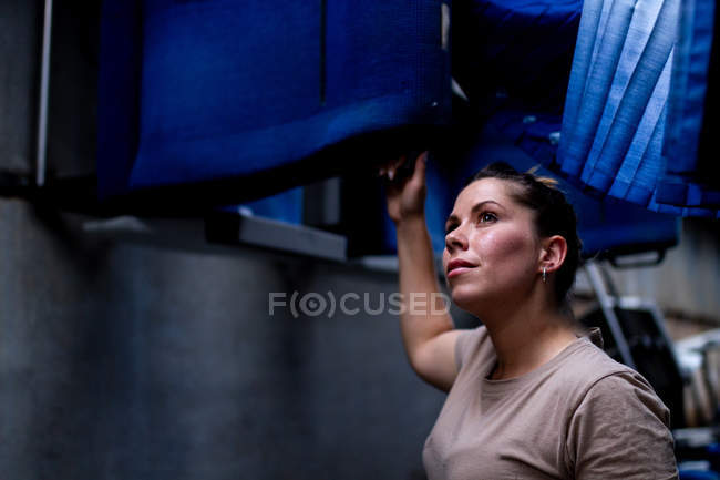 Attractive female soldier looking up while standing inside modern military transport — Stock Photo