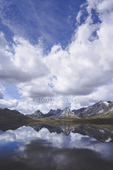 Nuvens brancas flutuando sobre cume da montanha e superfície calma do lago Embalse del Casares em Leon, Espanha — Fotografia de Stock