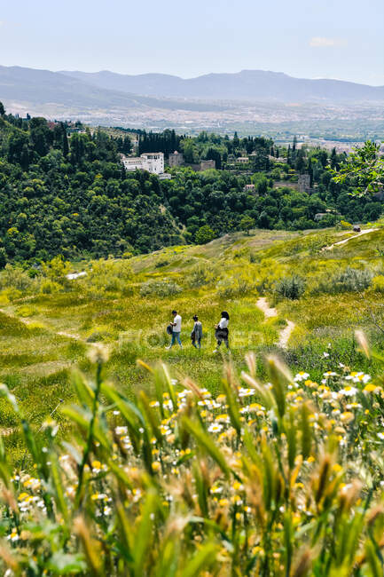 Gruppo di amici che camminano su un sentiero in una giornata di sole mentre visitano Granada In Spagna — Foto stock
