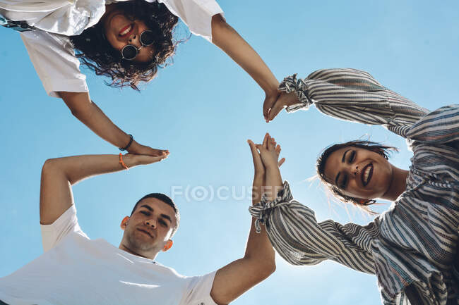 Gruppo di amici abbracciato e mettendo le mani insieme. Tutti loro molto felici e mostrando felicità — Foto stock