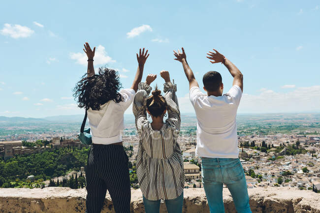 Група друзів займається туризмом в Іспанії і роздумує над панорамними поглядами Альгамбри в Гранаді. — стокове фото