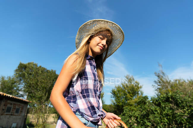 Jovem menina olhando para a câmera no rancho alimentando galinhas — Fotografia de Stock