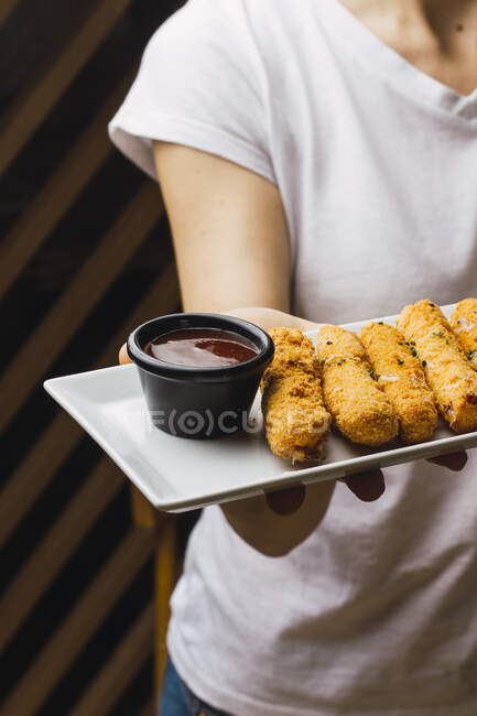 Chicken fillet in batter and red sauce — Stock Photo