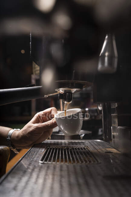 Crop hands of man making coffee by automatic professional equipment in cafe — Stock Photo