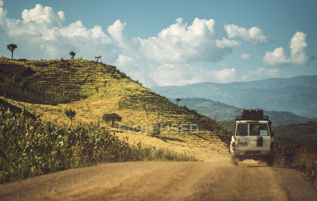 Landscape of beautiful green mountains with car driving on roadway in tropical sunlight, Ethiopia — Stock Photo