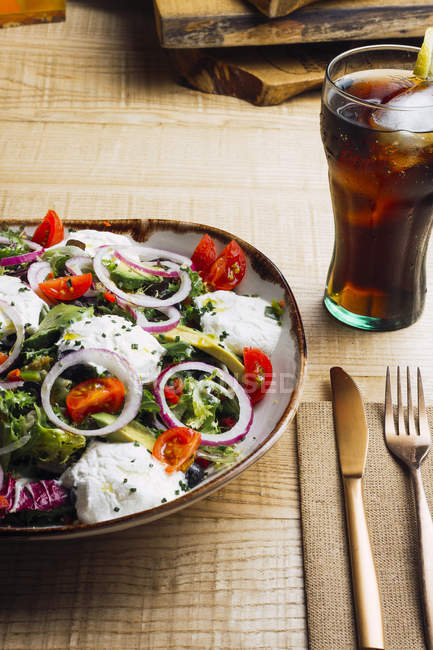 Овочевий салат з цибулею і вершковим соусом, поданий на тарілці на дерев'яному столі — стокове фото