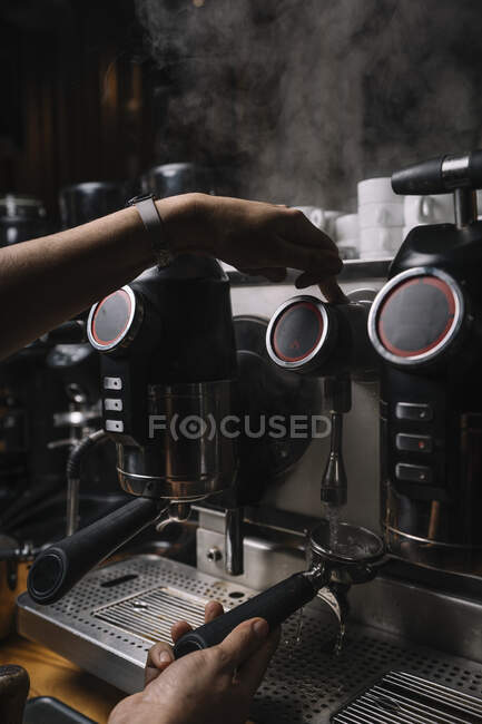 Crop hands of man making coffee by automatic professional equipment in cafe — Stock Photo