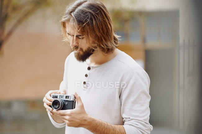 Giovane uomo bello barbuto in abiti casual scattare foto in strada — Foto stock