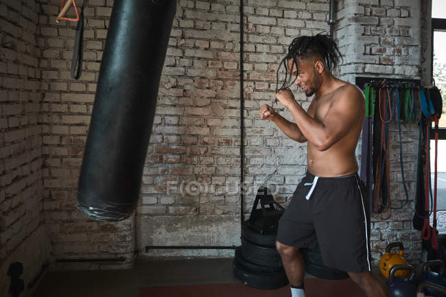 Чорний хлопець бокс в гранжевому спортзалі з цегляними стінами — стокове фото