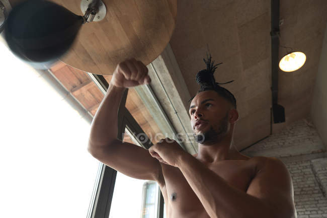 Снизу черный парень боксирует в спортзале — стоковое фото