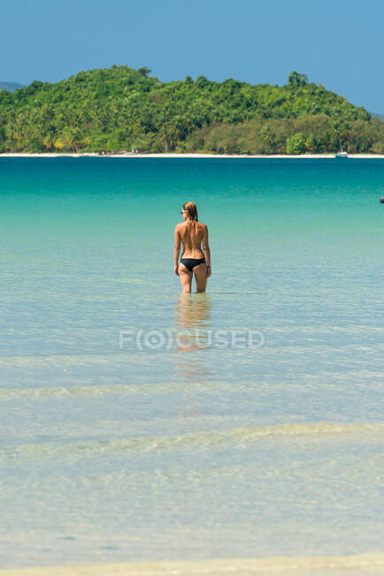 Жінка відпочиває у воді на тропічному узбережжі — стокове фото
