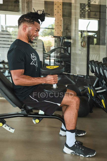 Strong man exercising with dumbbells in gym — Stock Photo
