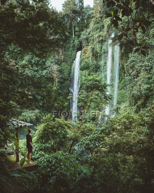 Tourist unter nebelverhangenem Wasserfall — Stockfoto