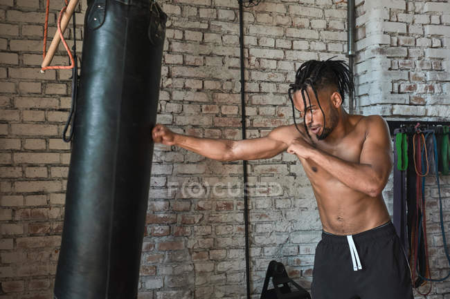 Black guy boxing en el gimnasio con paredes de ladrillo. - foto de stock