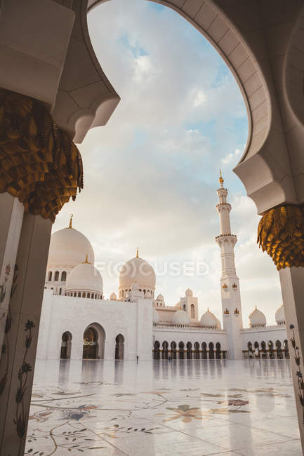 Mezquita blanca con cúpulas y minaretes bajo el cielo azul brillante, Dubai - foto de stock