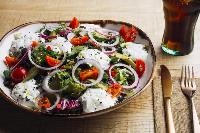 Овочевий салат з цибулею і вершковим соусом, поданий на тарілці на дерев'яному столі — стокове фото