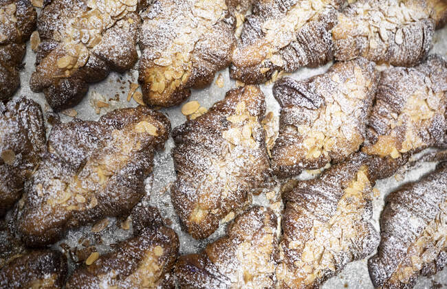 De acima mencionada composição de croissants franceses recentemente assados com amêndoas fatiadas e açúcar em pó — Fotografia de Stock