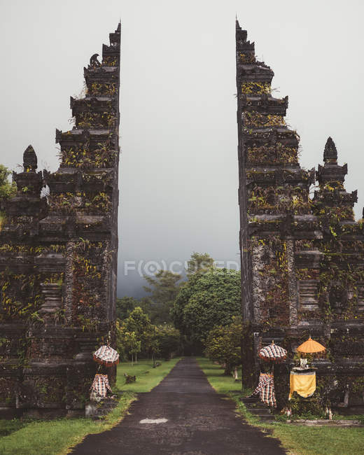 Paved roadway into ancient mossy gates of temple, Bali — Stock Photo