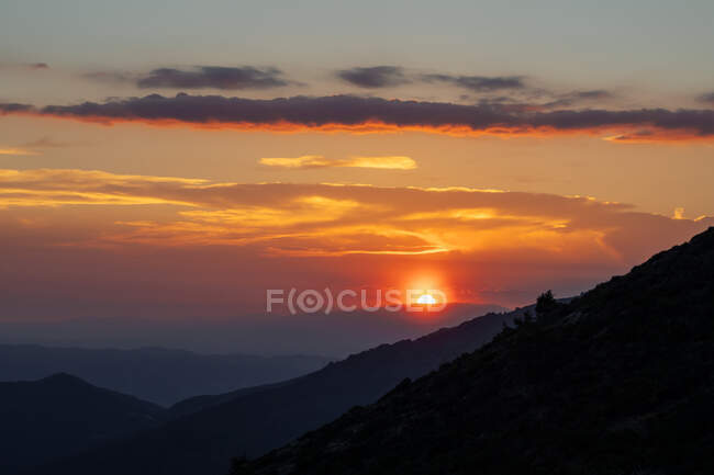 Pittoresca vista di maestoso tramonto luminoso sopra scure scogliere piccanti — Foto stock