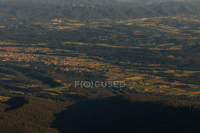 Захватывающий вид с воздуха на пейзаж с городом, полями и лесом — стоковое фото