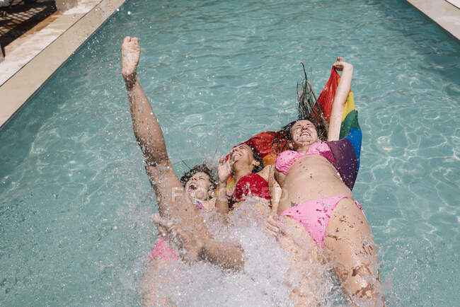 Anonymous lesbians splashing in swimming pool — Stock Photo