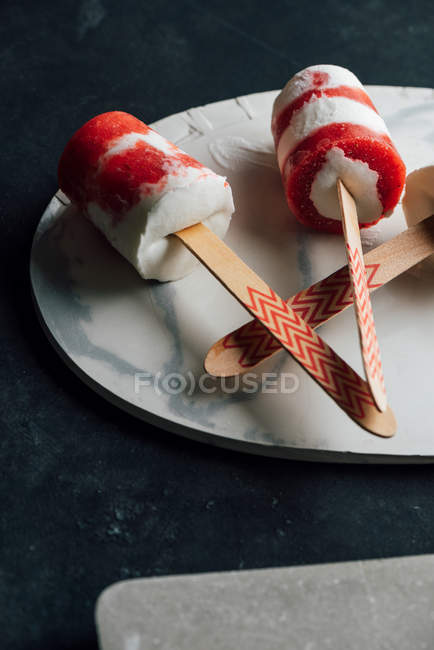 Closeup of several watermelon and cream ice-cream on plate on dark background — Stock Photo