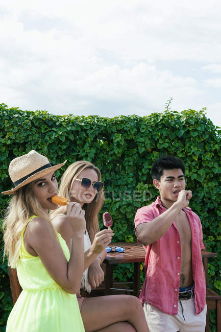 Друзі їдять морозиво, розмовляючи на терасі в барі — стокове фото