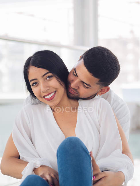 Jovem homem bonito com olhos fechados abraçando atraente mulher sorridente — Fotografia de Stock