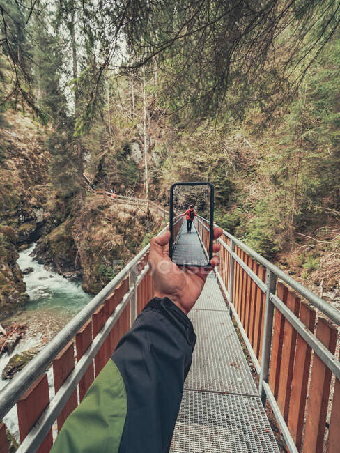Traveller taking photo of hiker friend while walking on hiking footpath of picturesque area in Dolomites, Italy — Stock Photo
