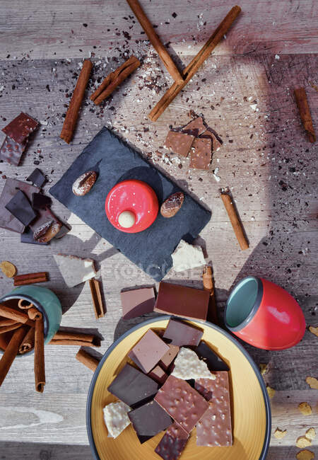 Зверху дошка шиферу з малиновим мусом на столі серед безладних інгредієнтів з паличками з шоколадом та корицею — стокове фото