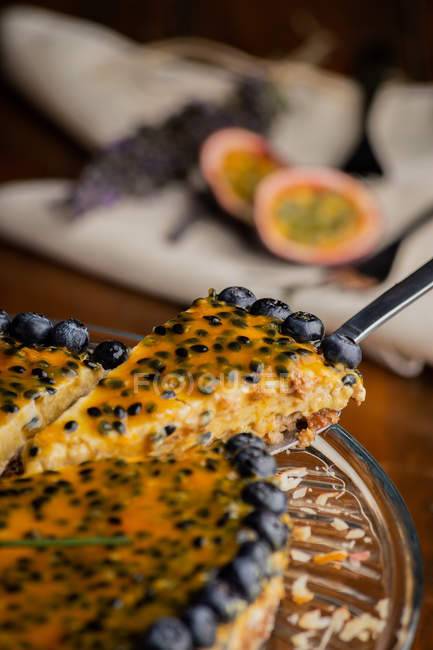 Closeup of appetizing fragrant passion fruit pie with blueberry topping decorated with bunch of lavender — Stock Photo