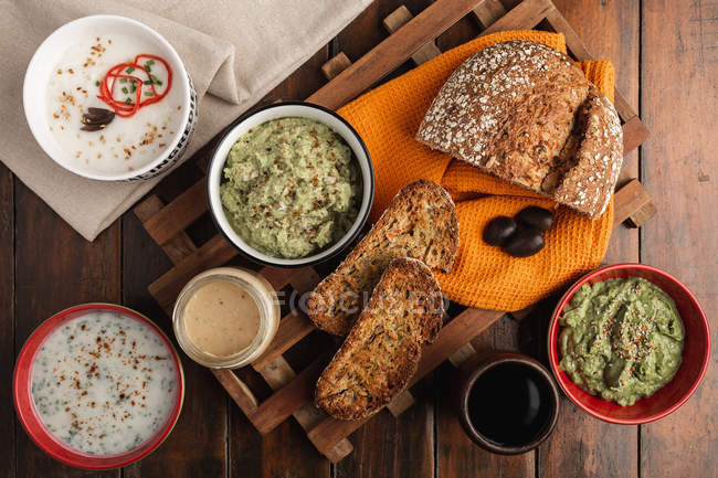 Вкусные соусы, украшенные кунжутом и пышным хлебом — стоковое фото