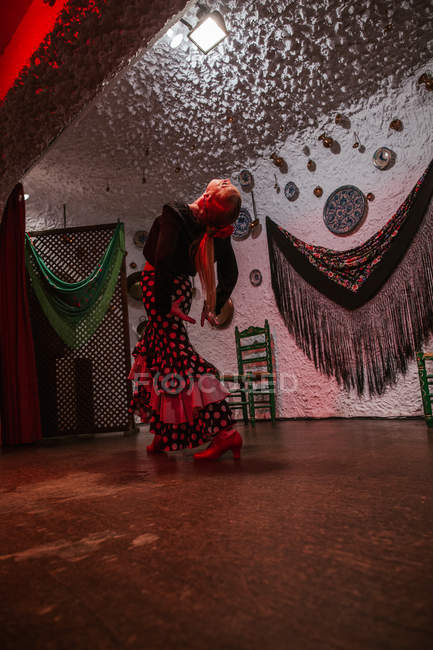 Female dancer in flamenco costume standing in dance posture on scene — Stock Photo