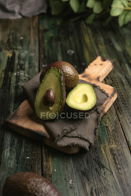 Свежие авокадо на деревенском деревянном столе — стоковое фото