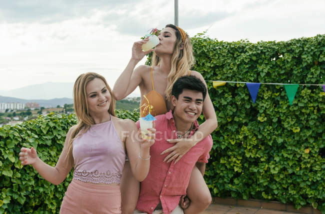 Grupo de amigos que se divierten mientras bailan, reían y beben cócteles. - foto de stock