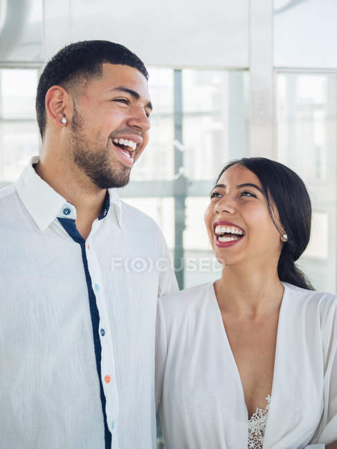 Lovely young couple in light clothes looking at each other with love and tenderness indoors — Stock Photo